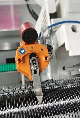 Macchina a maglia per la produzione di colletti e manubri a forma di jacquard di tipo piatto con sistema di carico